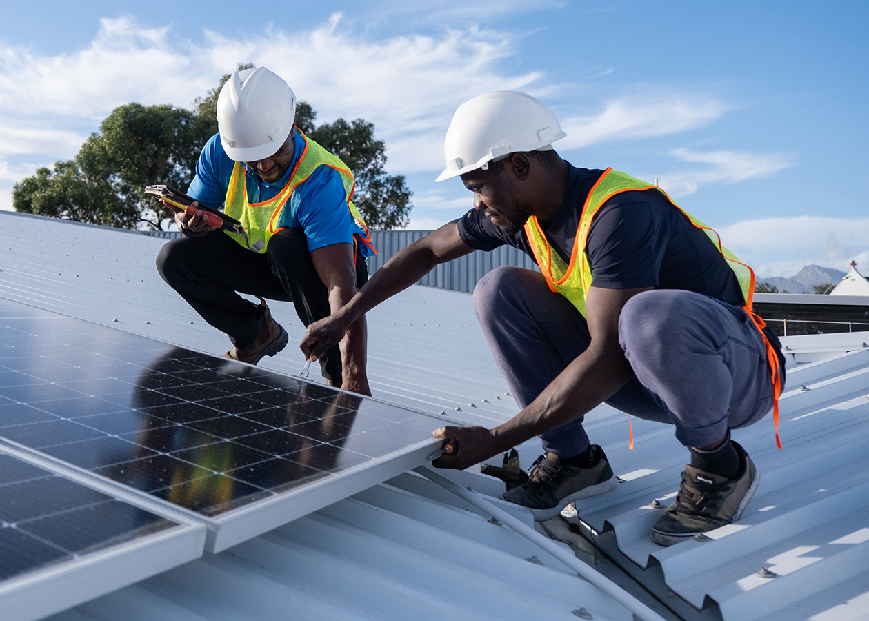 Two workers installing solar panels